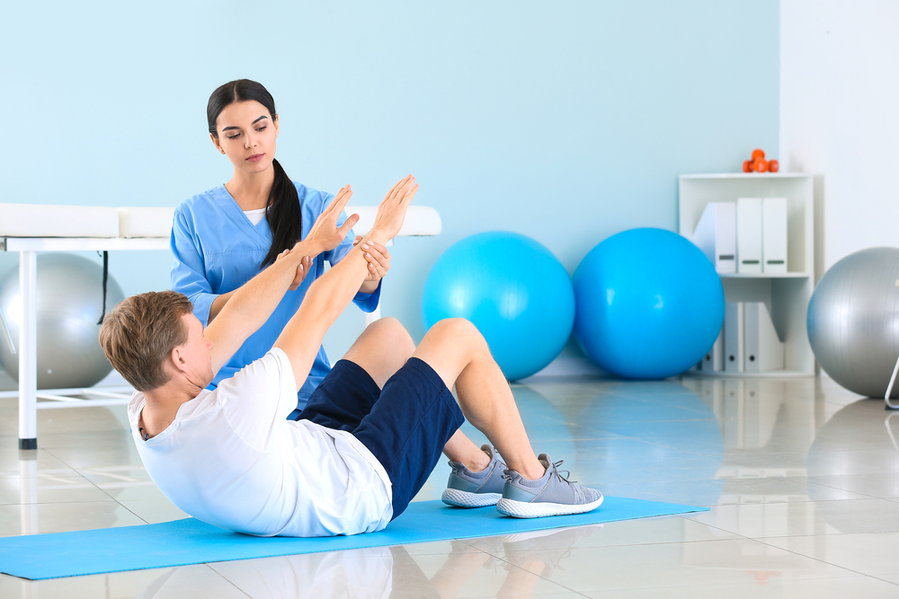 a physical therapist assisting a patient in doing exercises