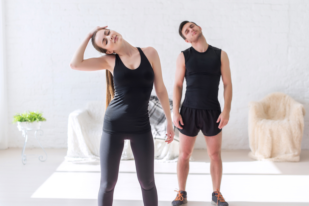 a man and woman in workout gear doing neck exercises