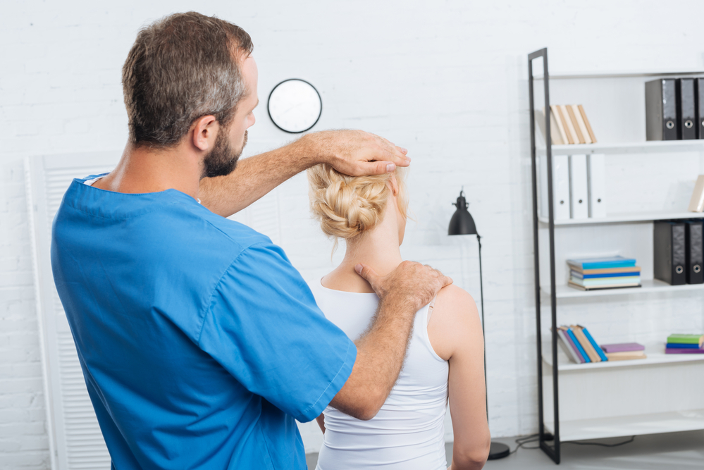 a physical therapist performing a neck stretch on a patient