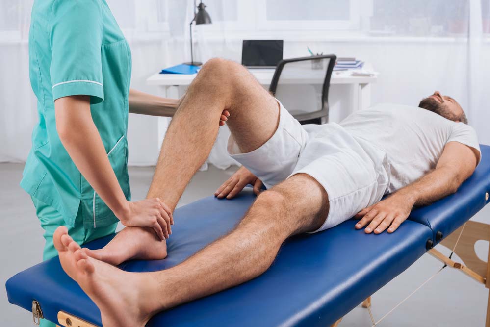 a physical therapist treating a patient’s knee